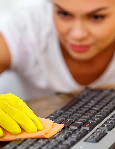 HANI Gebäudereinigung Büroreinigung - Bild zeigt Frau, die eine Tastatur in einem Büro reinigt